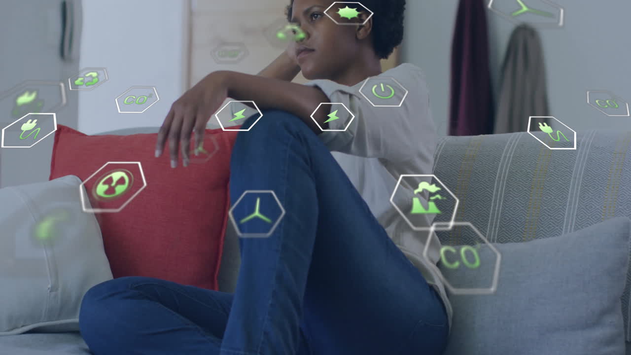Sitting on couch, person surrounded by floating eco-friendly animation icons