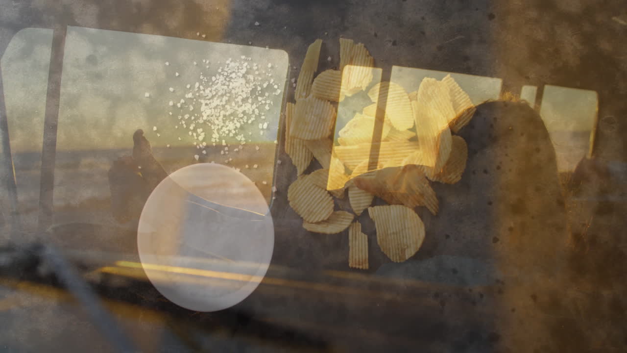 Potato chips and salt shaker animation over scenic landscape view from window
