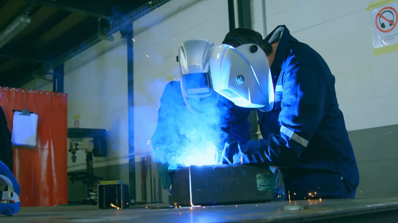 Robotic engineers welding metal in robotic warehouse 4k