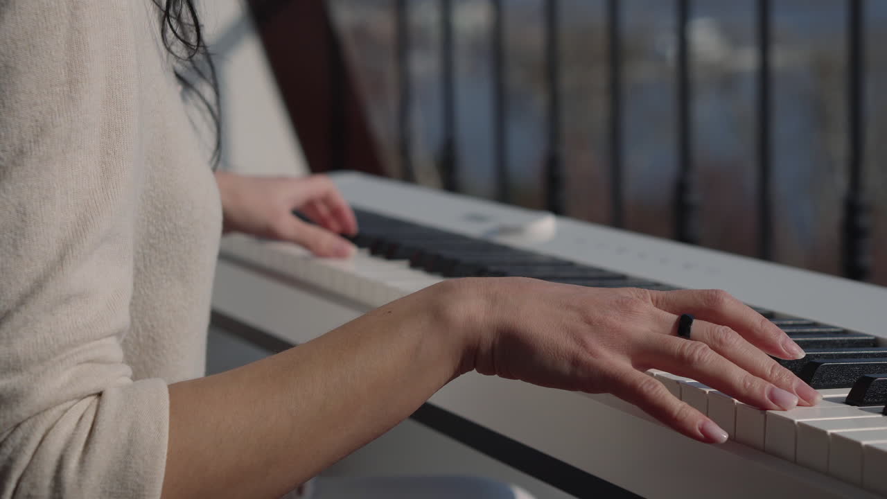 mujer tocando el piano en un balcón