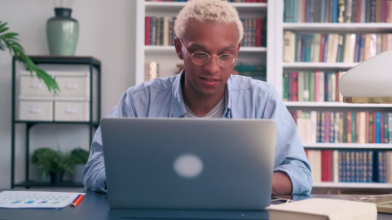 Young african american man starts working or doing online learning on laptop