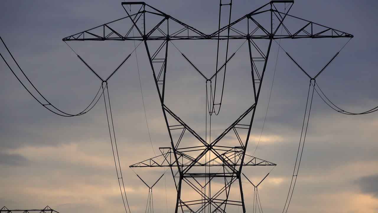 침울한 흐린 저녁 하늘을 배경으로 전기 타워와 송전선