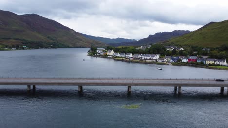 Autos-Conduciendo-Sobre-El-Puente-Cerca-Del-Castillo-De-Eilean-Donan-En-Dornie,-Costa-Oeste-De-Escocia,-Tierras-Altas-Escocesas---Drones-Aéreos-4k-Hd-Imágenes-Vuelan-Hacia