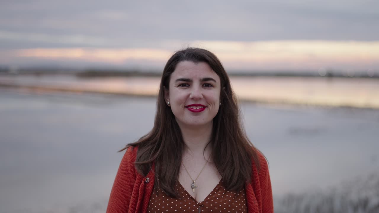 Woman taking photos at sunset by the lake