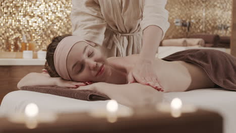 mujer joven haciendo masaje en el salón de spa