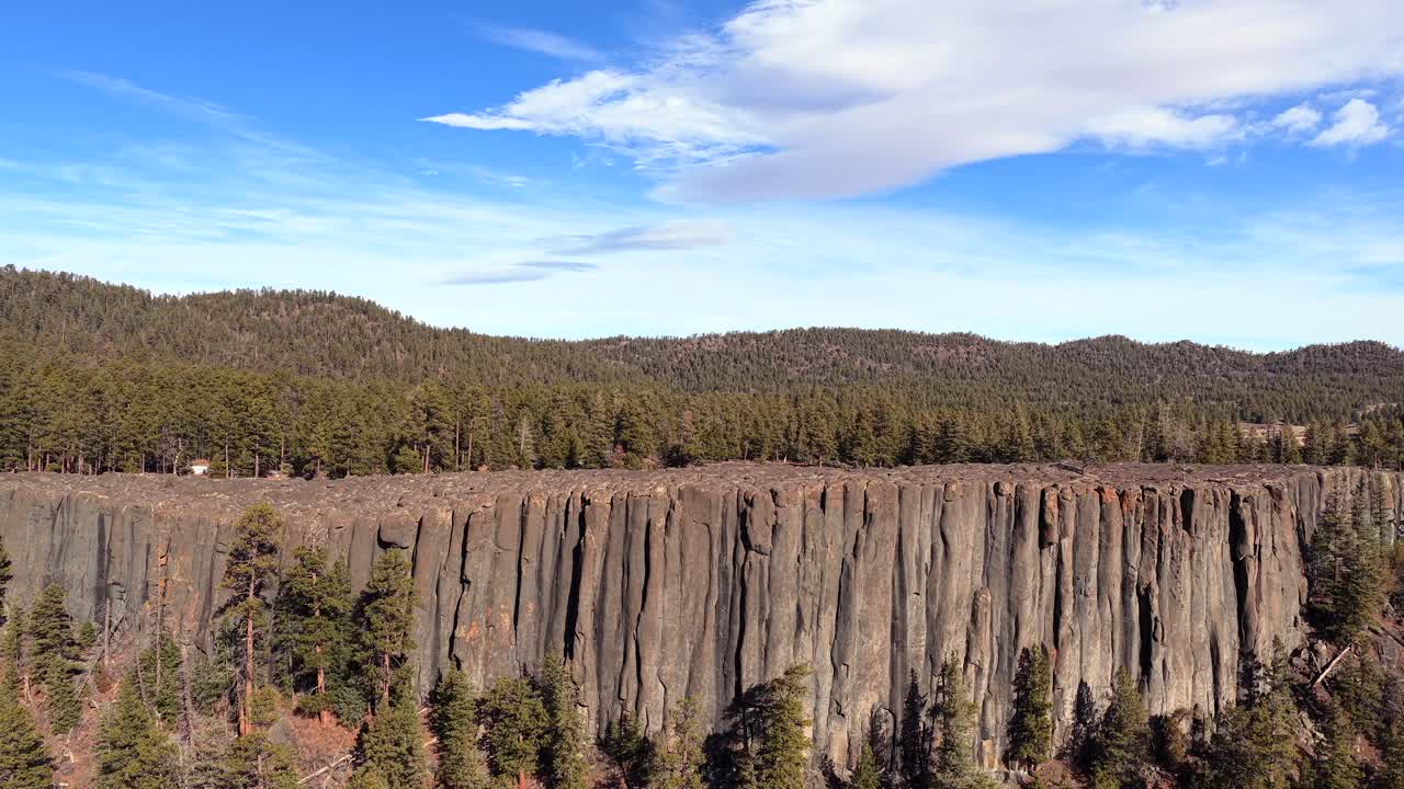 Uma vista panorâmica de drone revela a precisão geométrica de antigos tubos de órgão de pedra. Esta vista em 4K captura um paredão vulcânico íngreme que se eleva acima de uma exuberante natureza selvagem sempre-verde.
