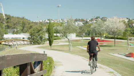 back view of cyclist with artificial leg pedaling in nature