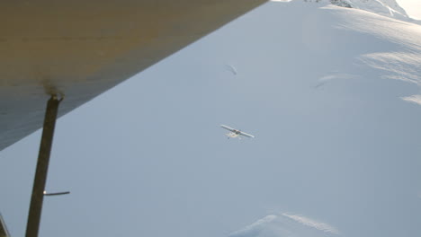 seguimiento aéreo pequeño avión sobre campo de nieve