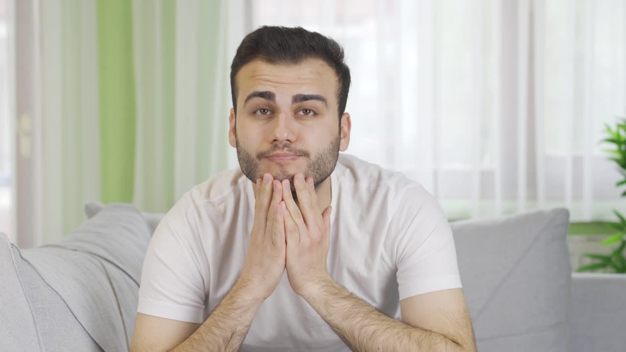 un joven deprimido, triste en su casa, miserable e indefenso.