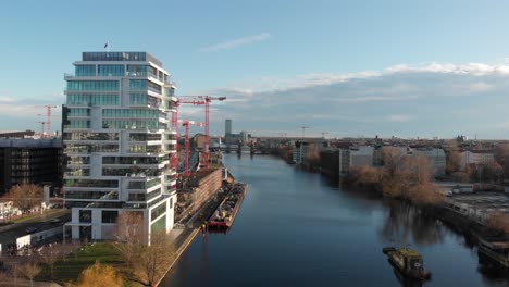 Berliner-Mauer-Von-Der-Spree-Mit-Einer-Drohne,-Die-Entlang-Des-Flusses-Fliegt-Und-Die-Berliner-Fernsehantenne-In-4k-24fps-Zeigt