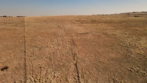 Antiguos-Senderos-En-Un-Campo-De-Cultivo-Seco,-Que-Evocan-Una-Sensación-De-Historia-Y-Soledad-Bajo-Un-Cielo-Despejado;-Capturados-Con-Un-Dron