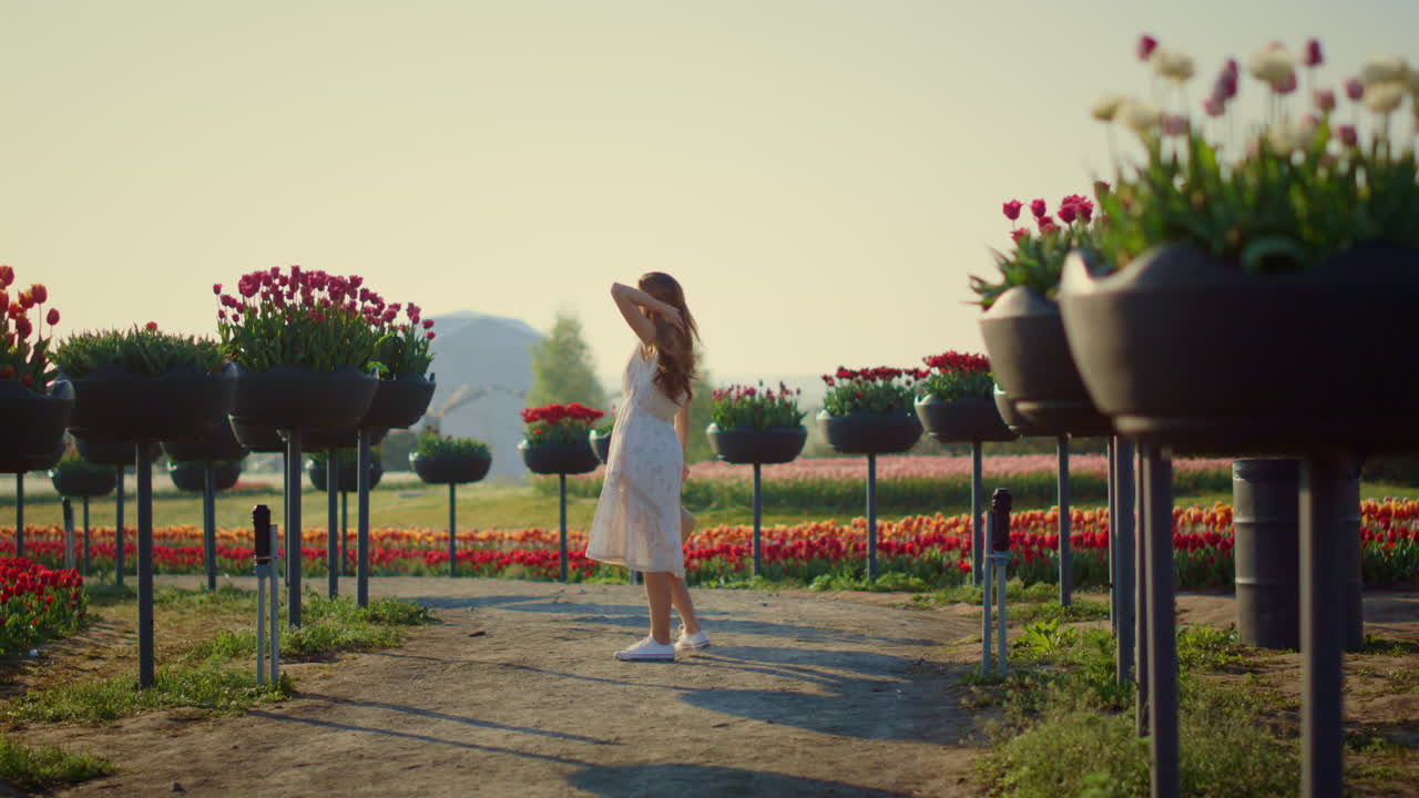 mujer delgada desconocida en vestido blanco disfrutando de un día de verano en un hermoso parque al aire libre
