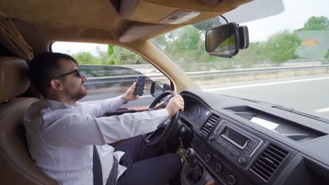 busy businessman talks on the phone while driving.