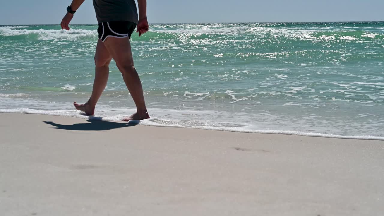 mujeres caminando en las playas de arena blanca con aguas claras de color esmeralda y olas en el golfo de méxico en un brillante día soleado de verano