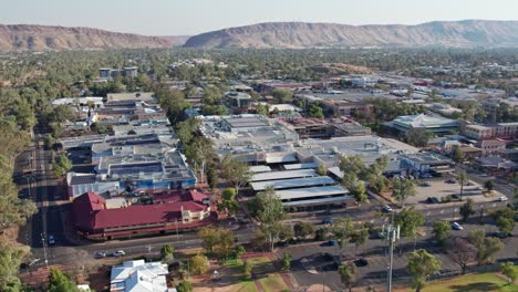 static drone footage over the town of alice springs, mparntwe, with macdonnell ranges and heavitree gap in the distance. northern territory, australia. august 2022.