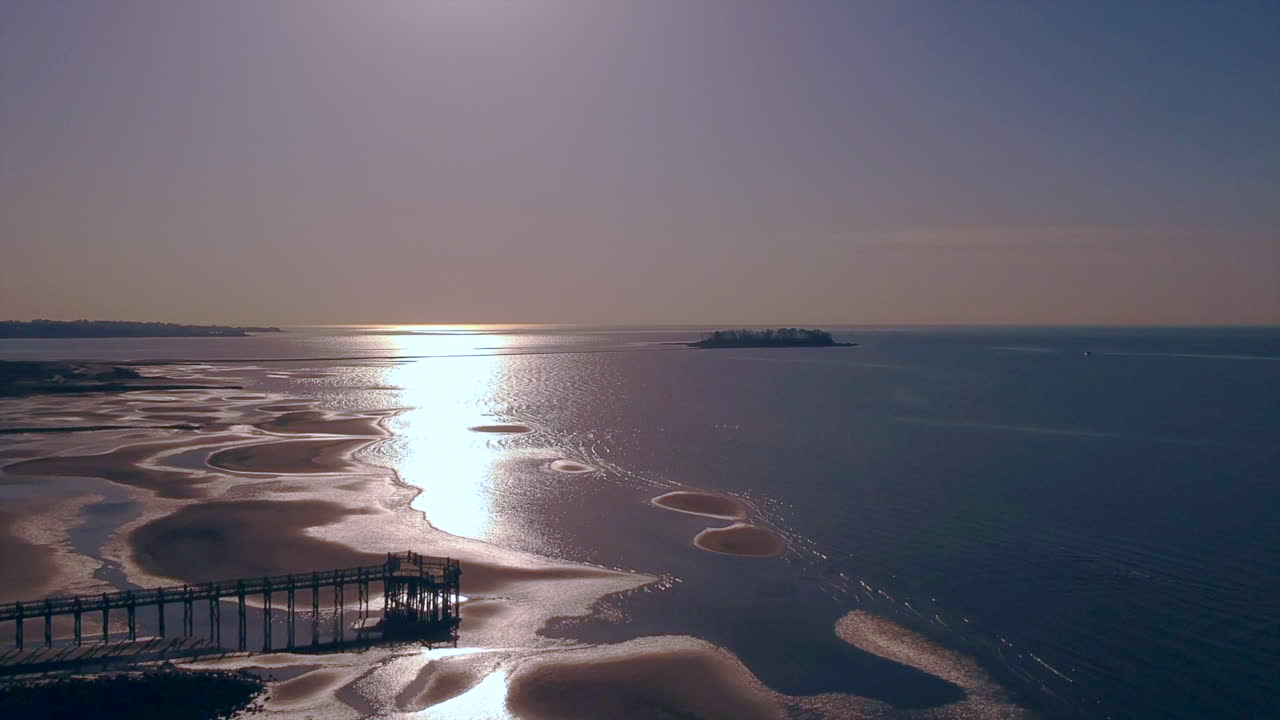 Drone ascending over a beach at sunrise