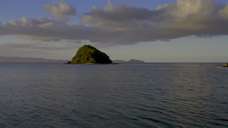 tropical island landscape with calm ocean and cloudy sky