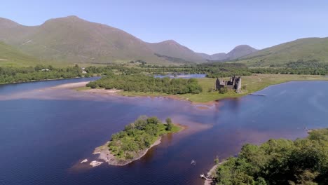 pan de ancho, de derecha a izquierda del castillo de kilchurn sentado en el asombro del lago en un día soleado