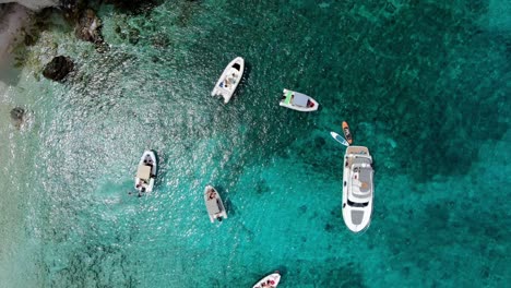 drone footage from tremiti island shows many boats and a yacht drifting in the crystal clear blue water