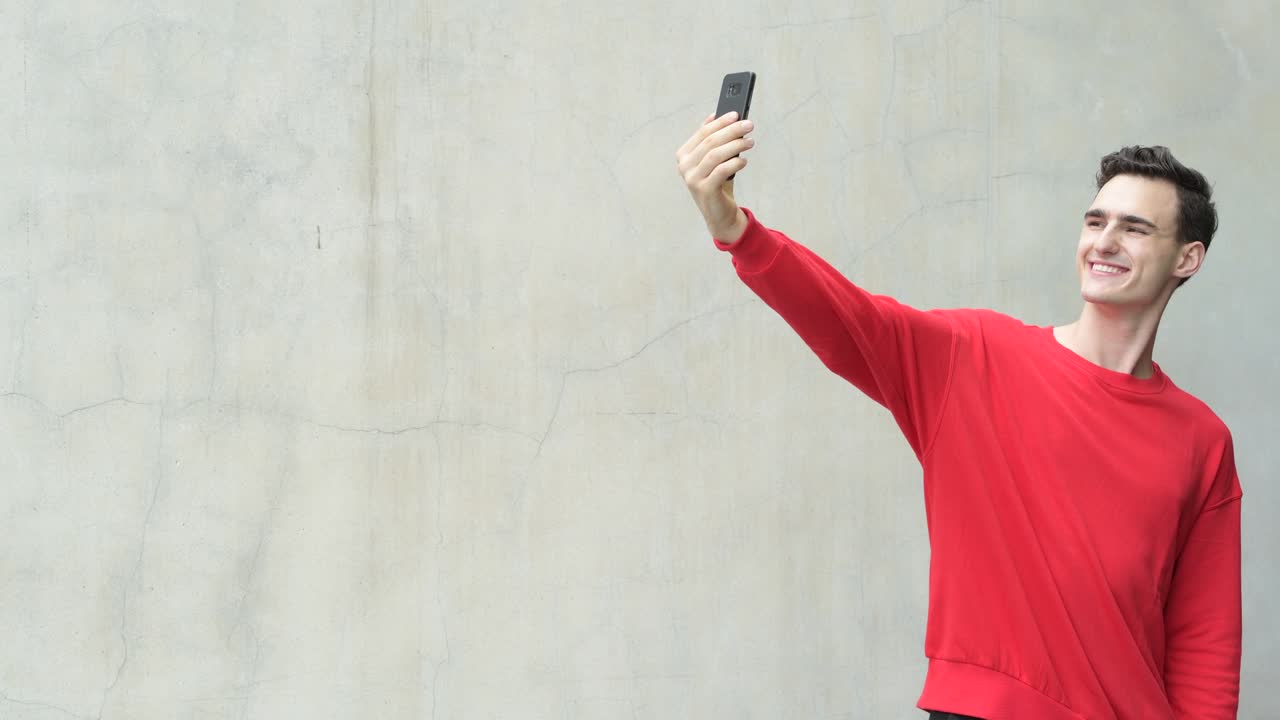 Young happy handsome man taking selfie
