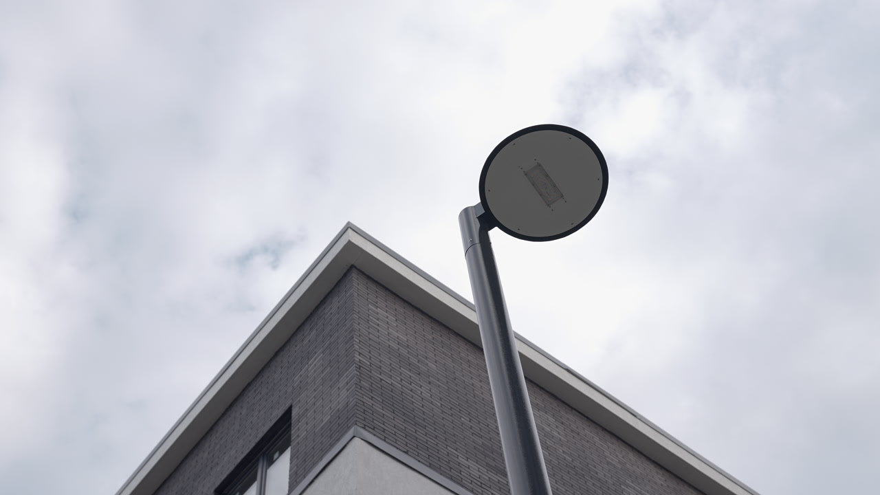 Round Lamp Head Against Cloudy Sky With Stainless Pole And Corner Of Modern Building, High Angle Perspective