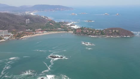 drone flying over the skies of ixtapa beach called isla grande located in the state of guerrero, mexico during a sunny day from a long distance