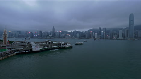 Horizonte-De-La-Isla-De-Hong-Kong-Visto-Desde-El-Paseo-Marítimo-De-Kowloon-Al-Atardecer-Bajo-Un-Cielo-Cambiante