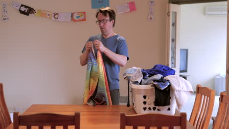 Domestic-man-folding-cloths-washing