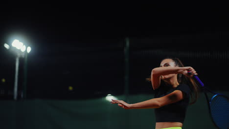 mujer jugando al tenis por la noche