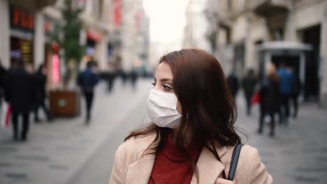 hermosa chica con máscara médica protectora y ropa de moda se encuentra en la calle