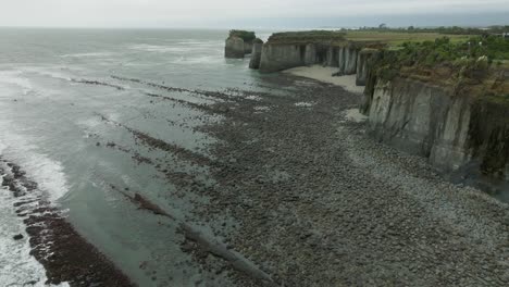 aerial view of rocky, rugged and wild coastal landscape at omau cliffs, cape foulwind, exploring the south island of new zealand aotearoa