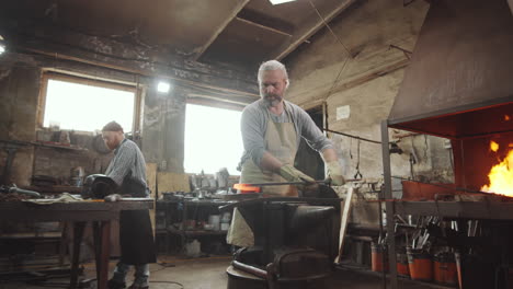 senior blacksmith working with wrought iron rod