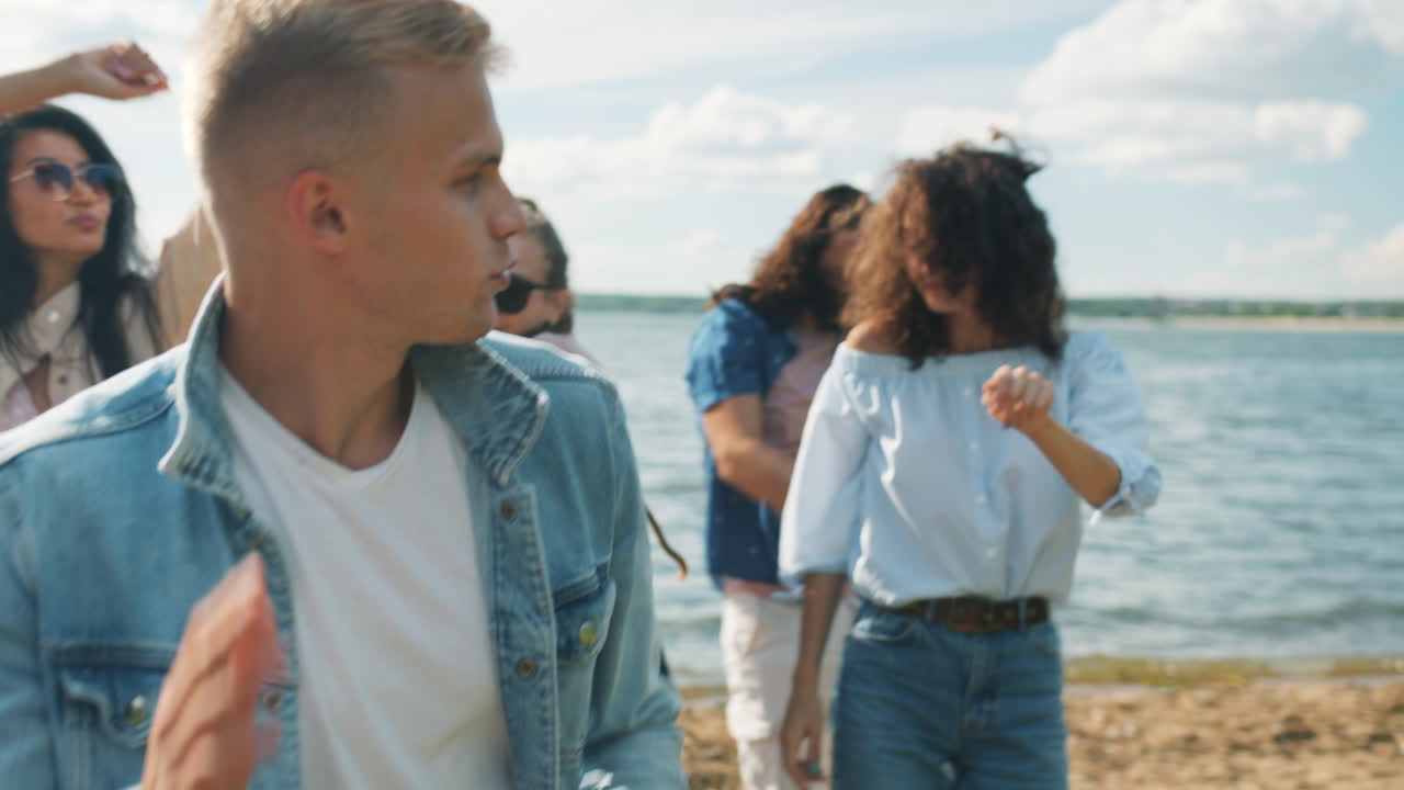 amigos bailando en la playa.