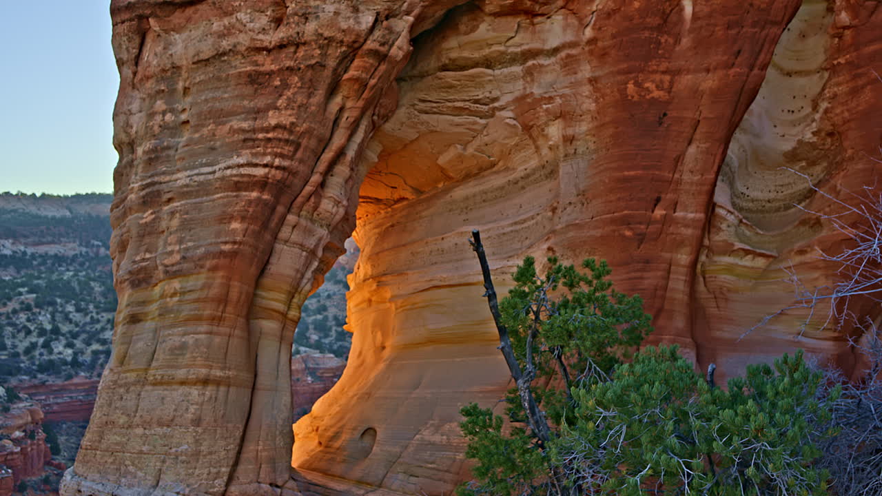 Overhead drone view of a breathtaking sandstone arch, framed by the golden hues of sunrise in Utah.