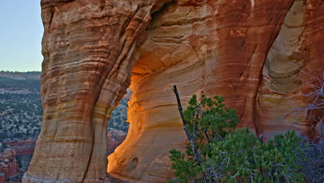 overhead drone view of a breathtaking sandstone arch, framed by the golden hues of sunrise in utah.
