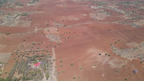 Aerial-of-dry-farmlands-with-green-trees-in-rural-Kenya
