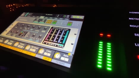 close-up of behringer x32 sound mixer board with active audio levels in use at event