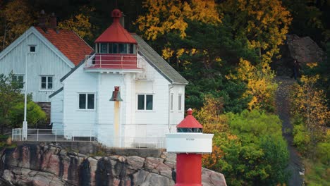 a lighthouse on the rocky shore of the fjord