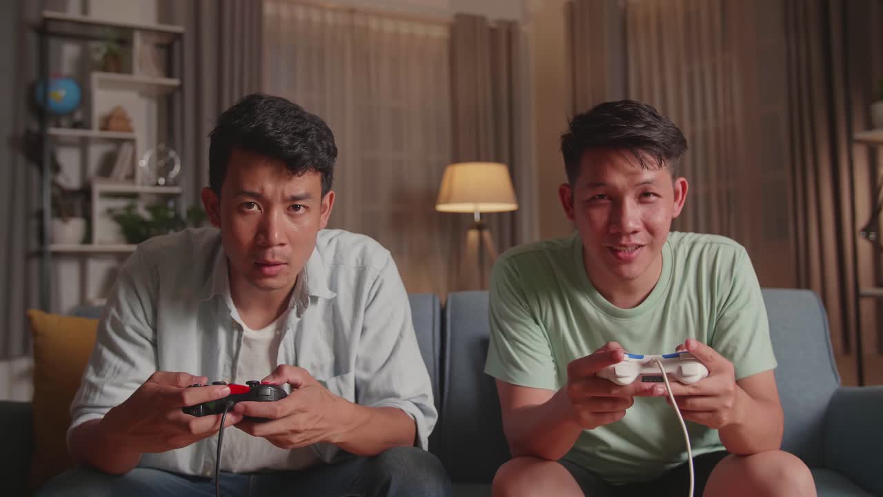 Asian Friends Playing Video Games And Celebrating Victory At Home