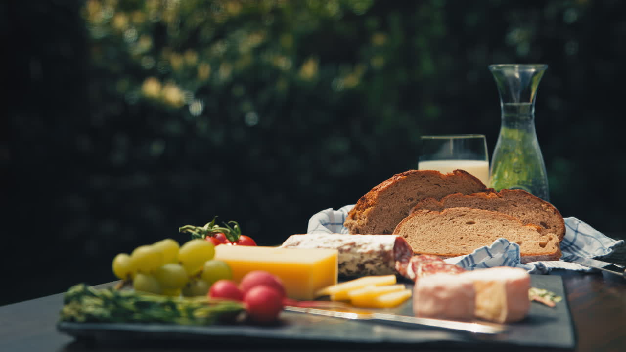 Vibrant outdoor table featuring delicious snacks like salami, cheese, and bread with decorations. Perfect for food blogs, picnic promotions, or gourmet product showcases