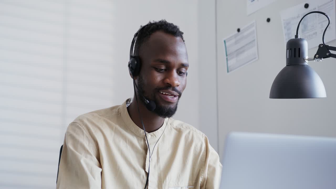 Businessman Using Headset and Laptop