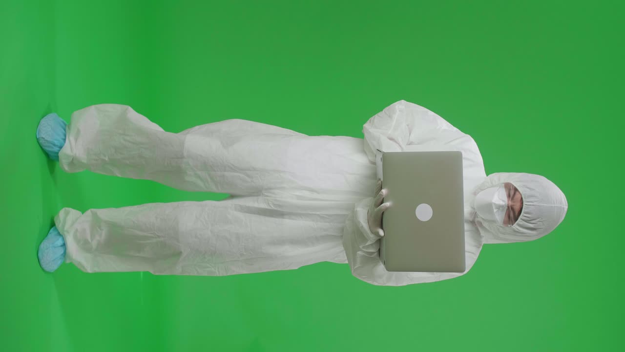 Person in Protective Suit Using Laptop