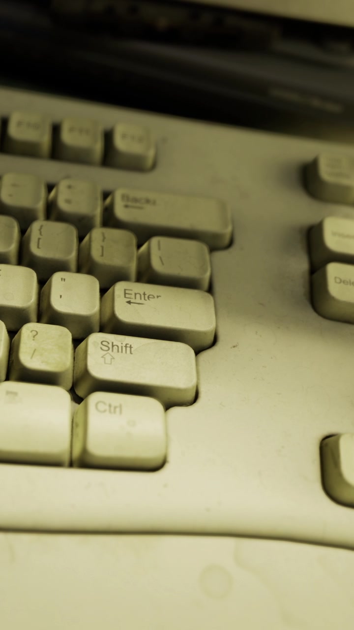 Old keyboard showing dust and signs of wear in a workspace setting