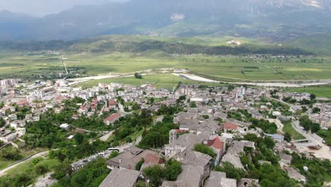 Drohnenansicht-In-Albanien,-Vertikaler-Aufstieg-In-Der-Stadt-Berat-über-Eine-Mittelalterliche-Burgfestung,-Die-Die-Ziegelbraunen-Dachhäuser-Von-Oben-Zeigt