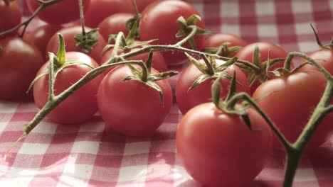 disparo de primer plano de tomates cereza frescos limpios en cuchillo de mesa de cocina de madera disparo de comida en cámara lenta, pequeñas frutas rojas junto con hojas verdes