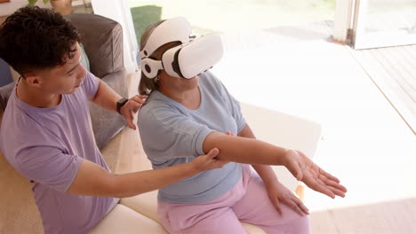assisting senior woman, male physiotherapist using vr headset for therapy session