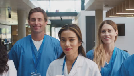 portrait of multi-cultural medical team wearing uniform standing inside hospital building