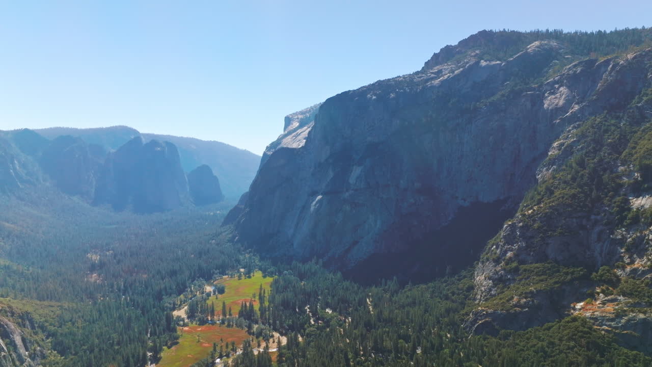 Bright sun lighting the beautiful valley among the huge mountains. Stunning scenery of Yosemite National Park, California, USA.