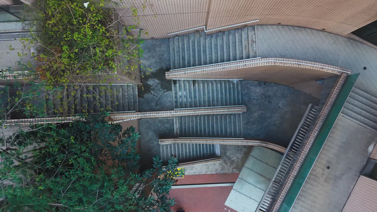 Toma cenital de una escalera en Hong Kong, revelando líneas geométricas, espacio urbano compacto y arquitectura superpuesta en una de las ciudades más densas del mundo.