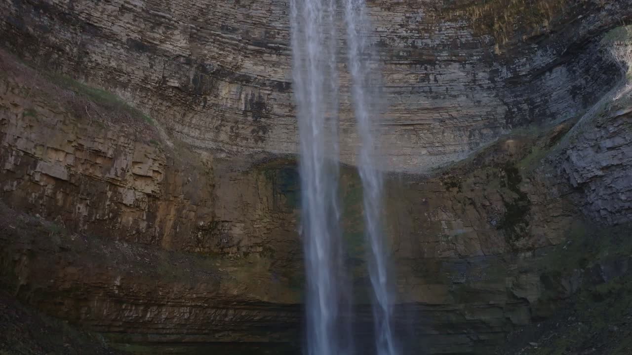 majestuosa cascada que desciende por un acantilado rocoso en una piscina serena debajo